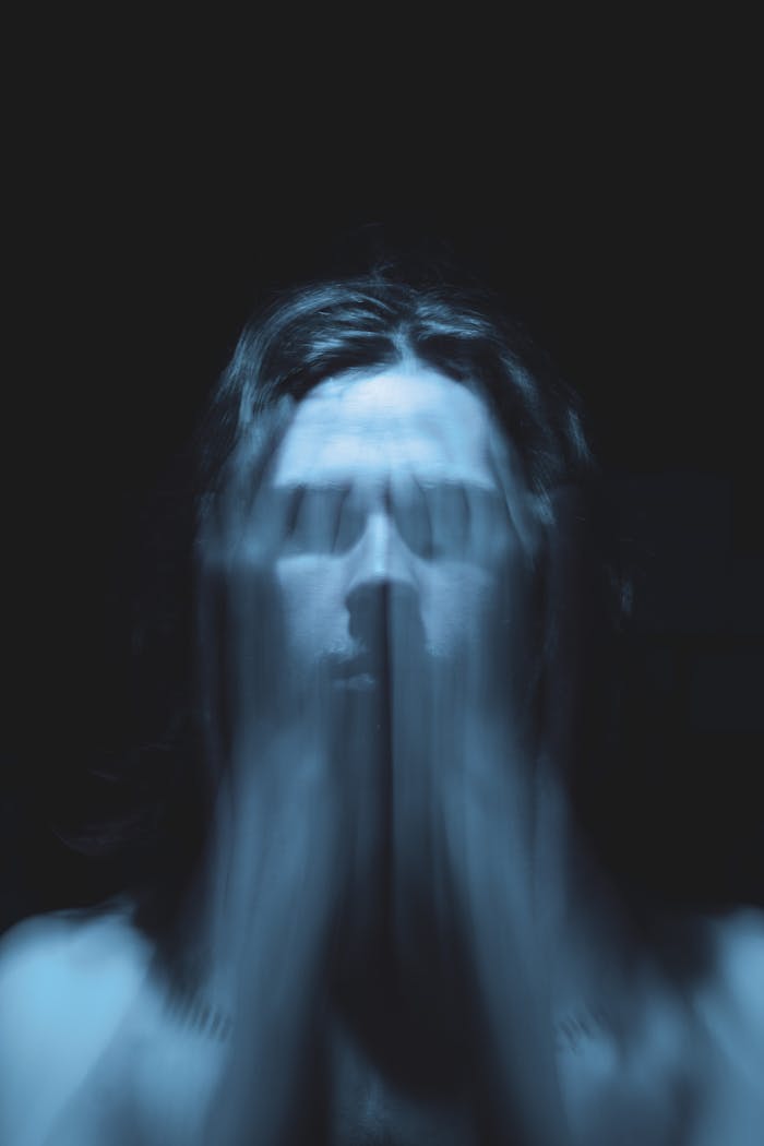 Artistic blurred portrait of a person in motion with a dark background.